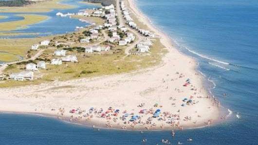 picturesque Island Houses, quaint expression, capturing charm, photorealistic, colorful cottages by the sea, highly detailed, flowers blooming in gardens, picturesque view, bright yellows and blues, clear morning light, shot with a prime lens.